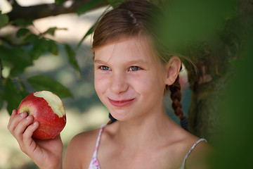 Image showing Smiling girl eating an apple