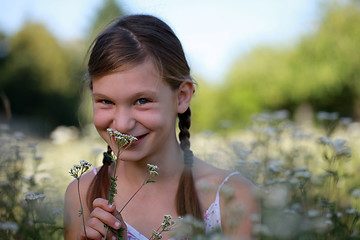 Image showing Young girl holding a flower