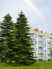 Image showing Apartment building, spruce trees and rainbow