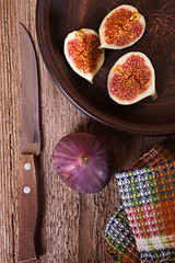 Image showing  fresh figs in a plate, old knife and towel 