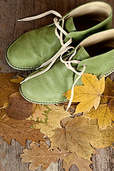 Image showing green leather boots and yellow leaves 