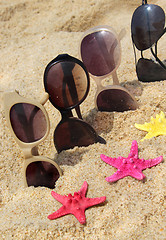 Image showing Four pairs of sunglasses on the beach 