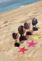 Image showing Four pairs of sunglasses on the beach 