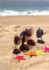 Image showing Four pairs of sunglasses on the beach 