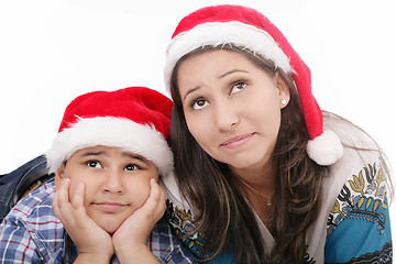 Image showing Mother and son in Santa hats smiling and looking up