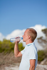 Image showing young man ist drinking water summertime dune beach sky