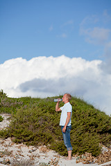 Image showing young man ist drinking water summertime dune beach sky