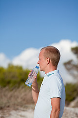 Image showing young man ist drinking water summertime dune beach sky