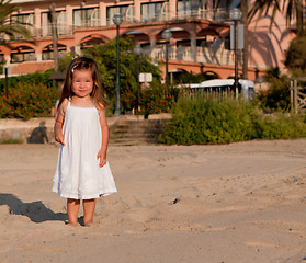 Image showing little cute girl smiling playing on beach in summer