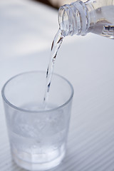 Image showing fresh cold clear mineral water in bottle and glass on table