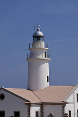 Image showing white lighthouse on rocks in the sea ocean water sky blue