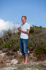 Image showing young man outside in summer on beach with mobile phone