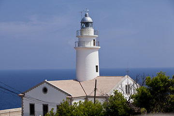 Image showing white lighthouse on rocks in the sea ocean water sky blue