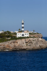 Image showing white lighthouse on rocks in the sea ocean water sky blue