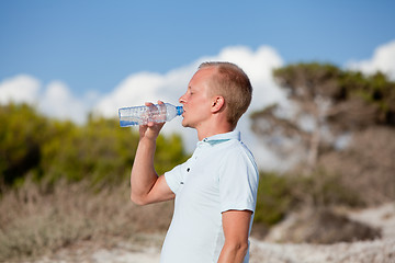 Image showing young man ist drinking water summertime dune beach sky