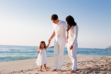 Image showing happy young family with daughter on beach in summer