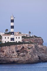 Image showing white lighthouse on rocks in the sea ocean water sky blue