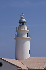 Image showing white lighthouse on rocks in the sea ocean water sky blue