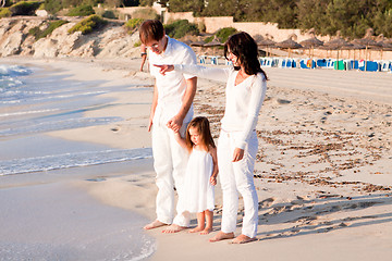 Image showing happy young family with daughter on beach in summer