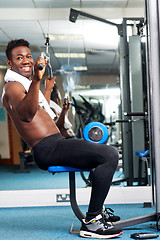 Image showing Fit african trainer working out in multi gym