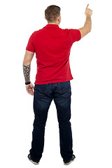 Image showing Back pose of man pointing at copy space area