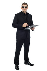 Image showing Male bouncer holding clipboard