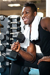 Image showing Young gym instructor toning his biceps