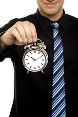 Image showing Business executive holding alarm clock. Cropped image