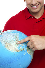 Image showing Cropped image smiling man pointing at the globe