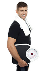 Image showing Healthy young man with a weight scale