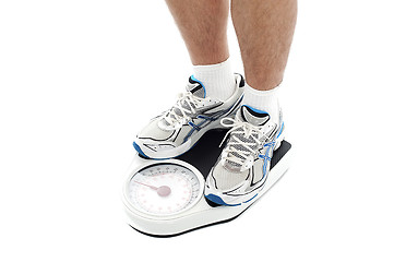 Image showing Male person standing on weighing scale. Extreme closeup