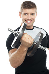 Image showing Gym instructor posing with heavy dumbbell
