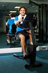 Image showing Smart guy working out in the exercise bike