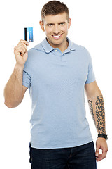 Image showing Trendy smart male showing credit card to camera