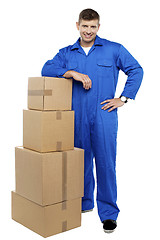 Image showing Relocation staff member resting against stack of cartons