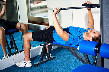 Image showing Fitness guy lying on bench and exercising