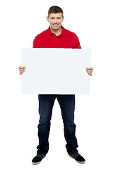 Image showing Handsome guy presenting blank billboard to camera