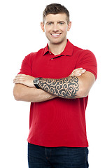 Image showing Stylish man with tattoo on hand posing with folded arms