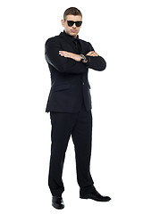 Image showing Young stylish bouncer in a black suit, arms folded