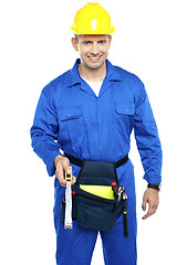 Image showing Repairman at work holding measuring tape