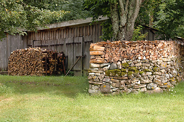 Image showing woodpile on stone wall