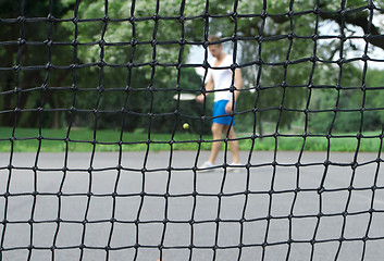 Image showing Tennis player seen through the net