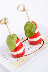 Image showing tasty tomatoe mozzarella salad with basil on white 