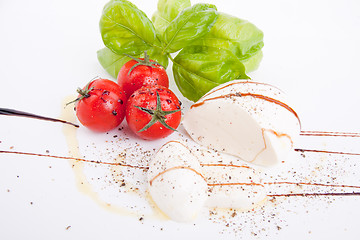 Image showing tasty tomatoe mozzarella salad with basil on white 