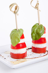 Image showing tasty tomatoe mozzarella salad with basil on white 