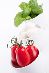 Image showing tasty tomatoe mozzarella salad with basil on white 