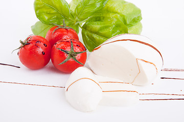 Image showing tasty tomatoe mozzarella salad with basil on white 