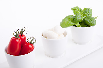 Image showing tasty tomatoe mozzarella salad with basil on white 