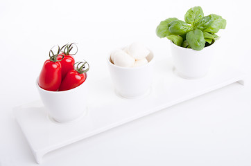 Image showing tasty tomatoe mozzarella salad with basil on white 