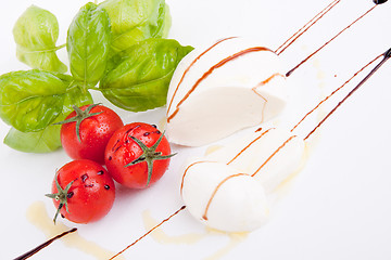 Image showing tasty tomatoe mozzarella salad with basil on white 